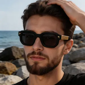 Détail de lunettes de soleil carrées noires avec flèche dorée sur la branche latérale