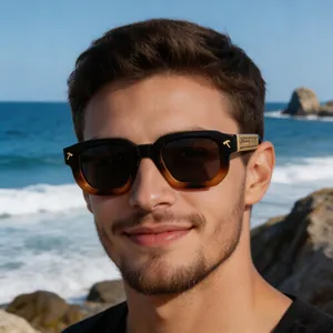 Gros plan de lunettes de soleil carrées dégradées avec détails dorés sur un mannequin homme