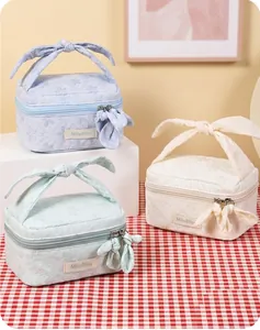 Close-up of floral jacquard makeup bags featuring elegant bow handles and fabric zip pulls