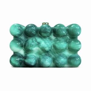 Detail of green marble acrylic clutch with sphere relief and golden metal clasp