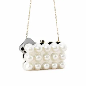 Detail of pearl evening bag showing interior capacity with a smartphone and gold chain