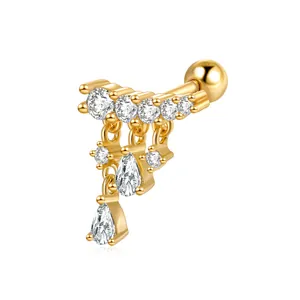 Macro detail of gold S925 silver ear stud with sparkling pavé zircons and teardrop charms