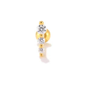 Macro shot of S925 silver gold-plated cartilage stud with three graduated clear zircon stones