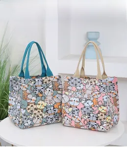 Close-up of canvas tote bags featuring cute cartoon cat prints and sturdy woven handles