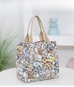 Close-up of a sturdy canvas lunch bag featuring colorful cartoon cat illustrations with handles