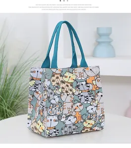 Detailed view of canvas tote bag featuring colorful cartoon cat prints and blue handles