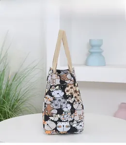 Detail of cartoon cat pattern canvas tote bag with sturdy woven handles in a home setting