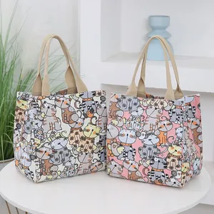 Minimalist canvas tote bag with cartoon cat print and beige woven handles for daily use