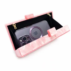 Pink marble acrylic evening clutch with gold metal rings and black lining for phone storage