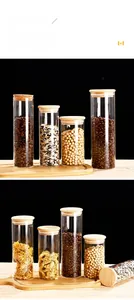 Stack of clear glass food jars with wooden lids for coffee beans and dry grains storage