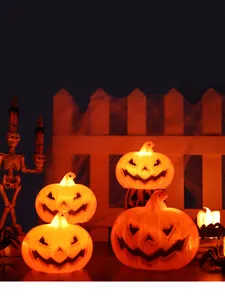 Close-up of four glowing orange pumpkin Jack-O'-Lanterns for Halloween party decor