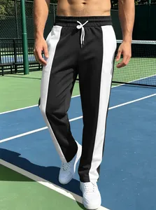 Detailed side view of men's athletic joggers featuring bold black and white contrast stripes
