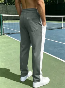 Detail of grey athletic joggers with white side stripes and comfortable elastic waist