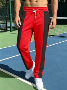 Detail of red athletic joggers featuring black side stripes and white adjustable drawstrings