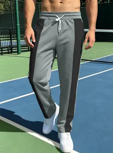 Close-up of men's athletic joggers featuring contrast grey and black paneling with drawstrings
