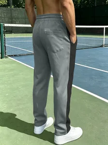 Detail of gray athletic joggers with side black stripes and a practical back pocket