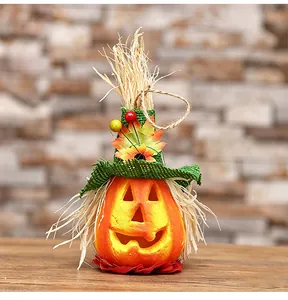 Hanging Halloween pumpkin decoration with straw hat, maple leaves and berries detail