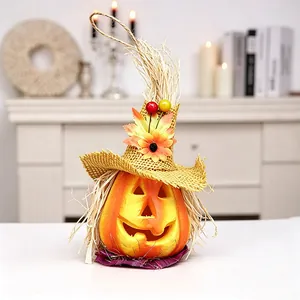 Halloween pumpkin decor with witch hat, sunflower and autumn leaves on warm indoor background
