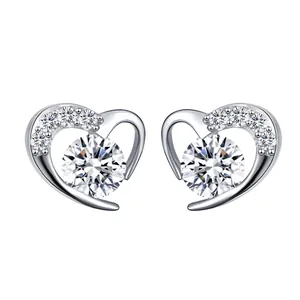 Detail of hollow heart stud earrings with sparkling round crystals in silver plating