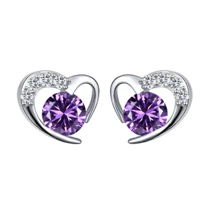Detailed view of silver heart stud earrings featuring a purple gemstone and small diamonds