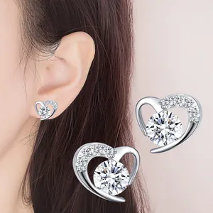 Detailed view of silver heart stud earrings with round crystal inlay and sparkling accents