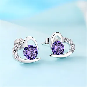 Macro shot of silver heart studs with purple gemstones and shimmering small diamonds