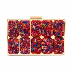 Detail of colorful acrylic shards inlay and gold metal frame on an evening clutch bag