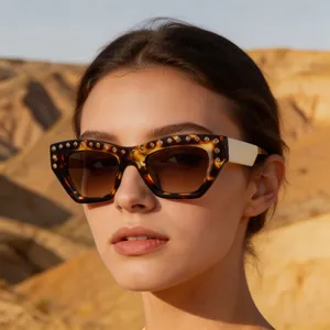 Close-up of tortoise shell cat-eye sunglasses with rhinestone details on a model