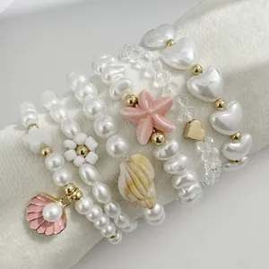 Vue détaillée d'un ensemble de bracelets en perles roses avec étoiles et coquillages