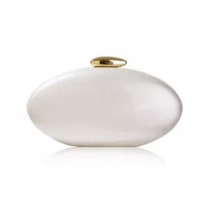 Detail of white pearlescent acrylic clutch with gold pebble clasp for weddings