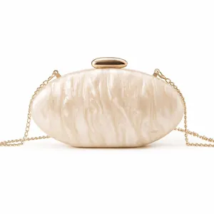 Detail of acrylic shell clutch with marble texture and golden pebble clasp for evening wear