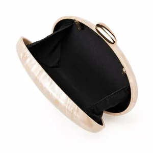 Macro view showing the cream marble acrylic shell and black lining of the shell clutch bag