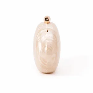 Side view of acrylic shell clutch bag featuring marbled cream finish and gold spherical clasp