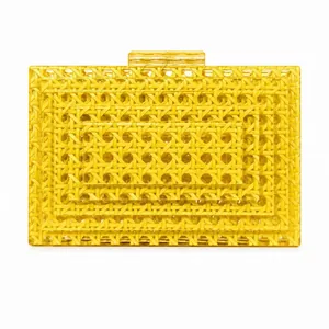 Macro detail of yellow acrylic evening bag featuring intricate woven rattan texture