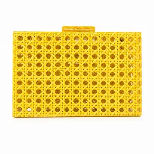 Detail of yellow acrylic clutch bag showing the intricate geometric cane webbing pattern