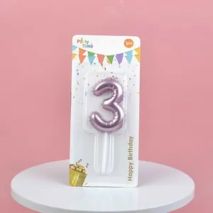 Macro view of metallic pink balloon-style number 3 birthday candle in retail packaging