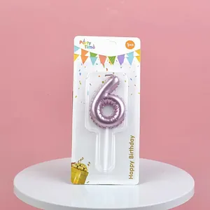 Detailed view of a pink metallic number 6 birthday candle in blister packaging