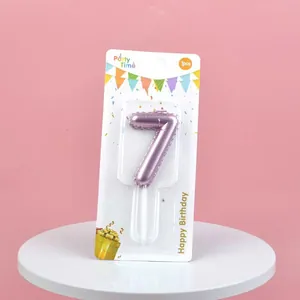 Detail of number 7 birthday candle with metallic pink finish in original packaging