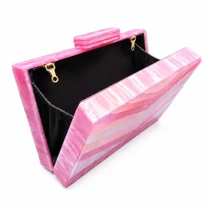 Macro detail of pink marble acrylic evening bag with black fabric lining and gold hardware