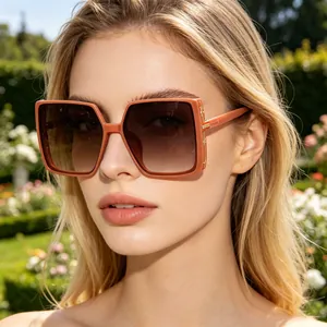 Close-up of coral orange square oversized sunglasses with brown gradient lenses