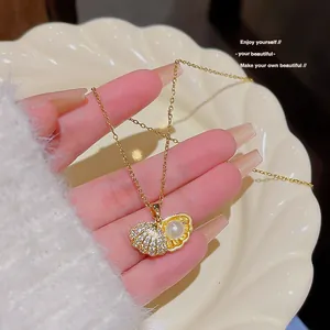 Golden heart shell pendant necklace with pearls and zircon in a lifestyle setting