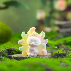 White nine-tailed fox figurine with pastel gradient tails and golden crown on moss