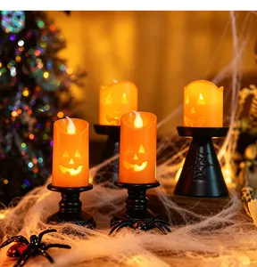 Detail of Halloween pumpkin LED candles with jack-o'-lantern faces and spider web bases