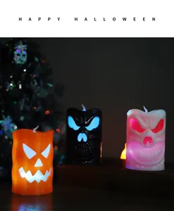 Close-up of glowing Halloween LED candles with pumpkin and skull faces in dark setting