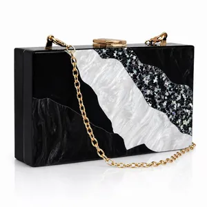 Detail of marble pattern acrylic clutch with silver glitter inlay and gold chain strap