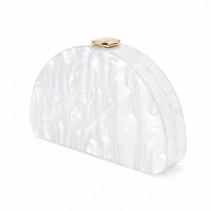 Detail of white mother-of-pearl texture acrylic evening clutch with gold metal clasp