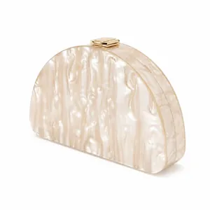 Detailed view of semi-circular acrylic clutch with pearlescent texture and gold clasp