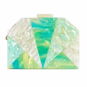 Detailed close-up of geometric acrylic clutch bag with marble texture and gold hardware