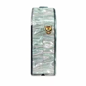 Detailed side view of light green acrylic evening clutch with gold metal hardware hooks