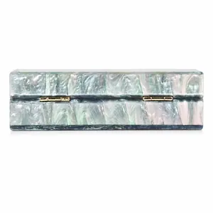 Detailed close-up of acrylic evening bag with marbled mother-of-pearl texture and gold hinges